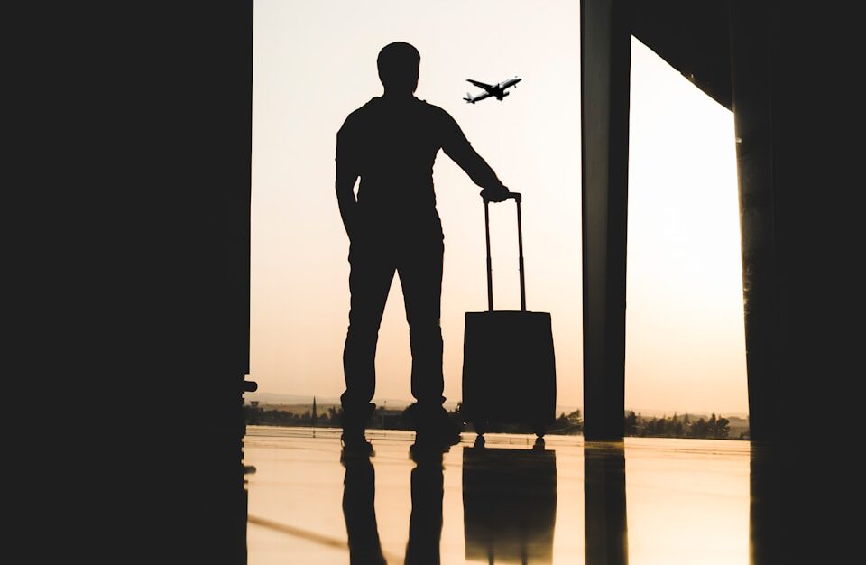 silhouette of man holding luggage inside airport