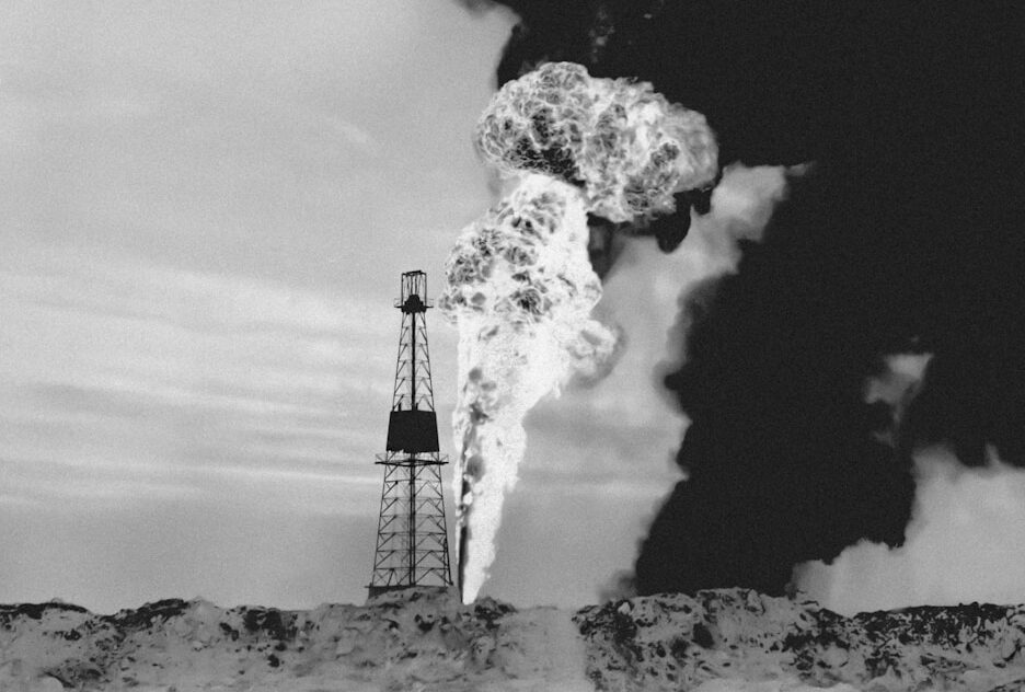 a black and white photo of smoke coming out of a pipe
