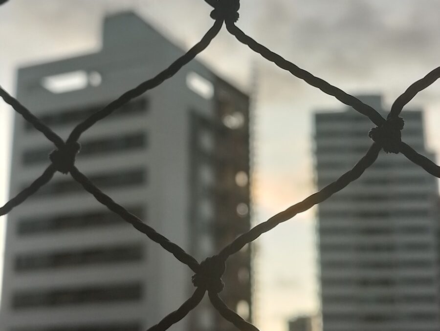 a view of a city through a chain link fence