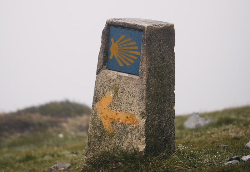 A stone marker with a blue and yellow arrow painted on it