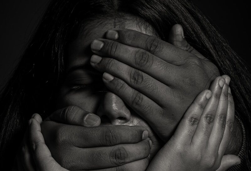 grayscale photo of woman covering her face with her hands