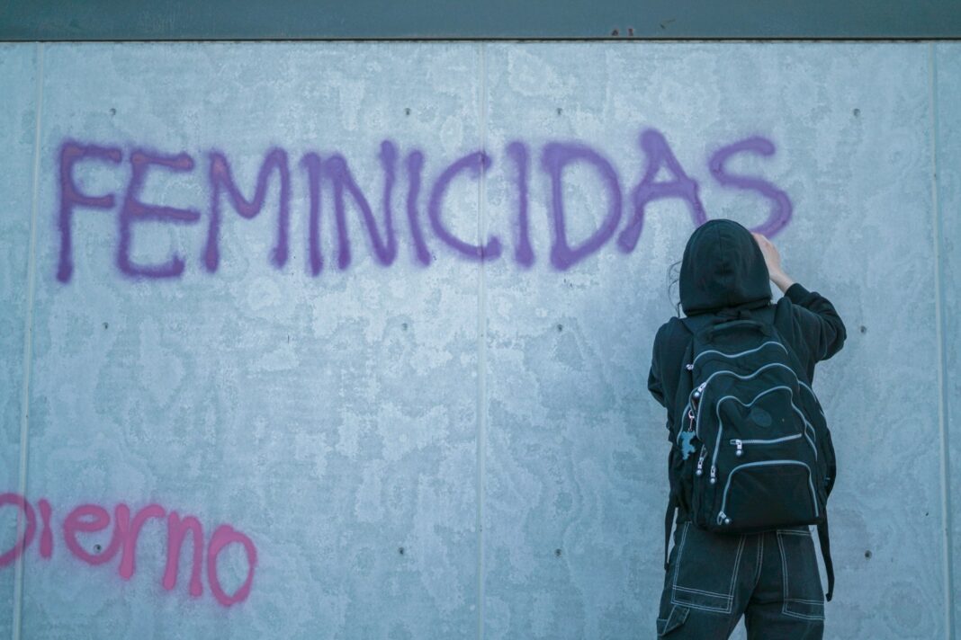 a person writing on a wall with graffiti