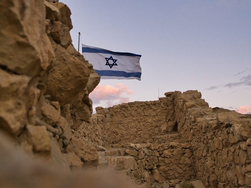 an israeli flag flying over a rocky area