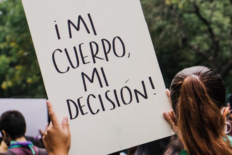 a person holding a sign that says i'm mi cuepro, mi decision