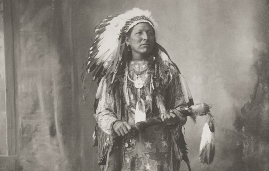 Native american man in traditional headdress and attire.