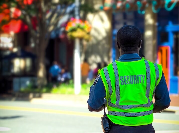 man in green and blue jacket walking on street during daytime