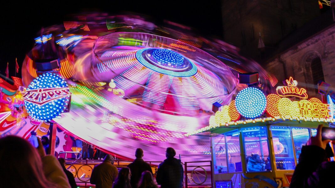 A group of people standing around a carnival ride