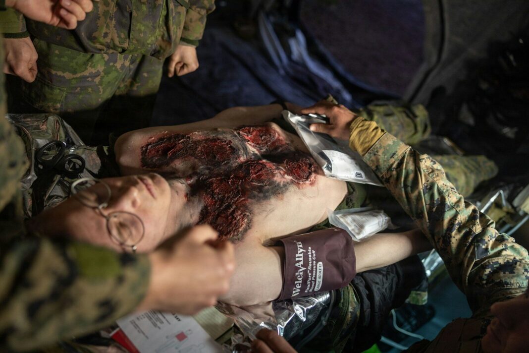 Injured person receiving medical attention from soldiers