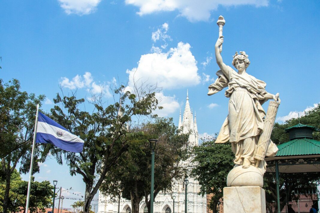 a statue of a woman holding a cup in front of a building